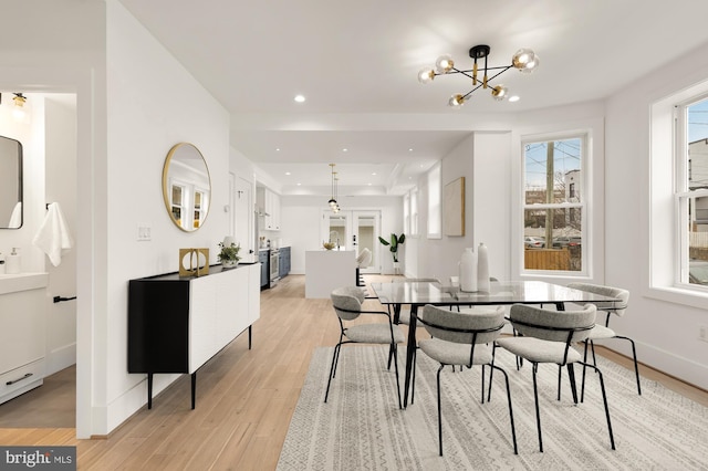 dining space featuring light wood-style flooring, recessed lighting, baseboards, and a chandelier