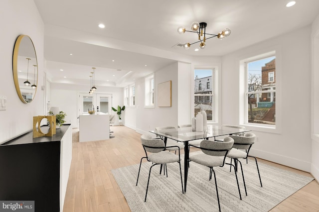 dining space featuring light wood finished floors, recessed lighting, an inviting chandelier, and baseboards