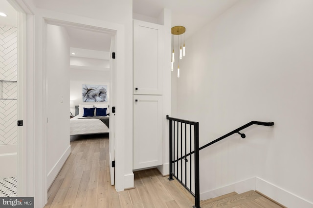 hall with recessed lighting, an upstairs landing, baseboards, and light wood finished floors