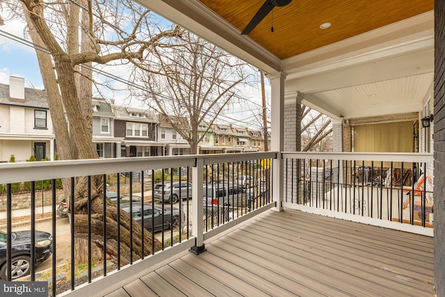 wooden deck with a residential view and a ceiling fan