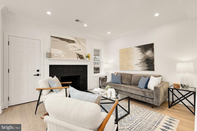 living area featuring a fireplace, recessed lighting, light wood-style floors, and visible vents