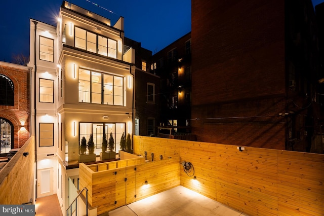 back of house at twilight with stucco siding