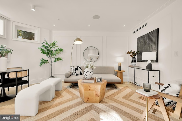 living area featuring visible vents, crown molding, baseboards, recessed lighting, and a decorative wall