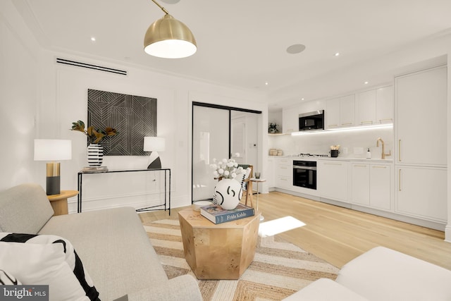 living area with recessed lighting, light wood-style floors, and visible vents