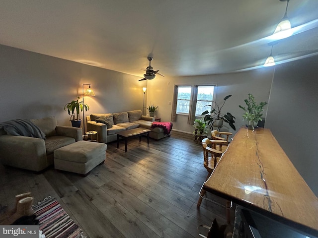 living room featuring dark wood-type flooring and ceiling fan