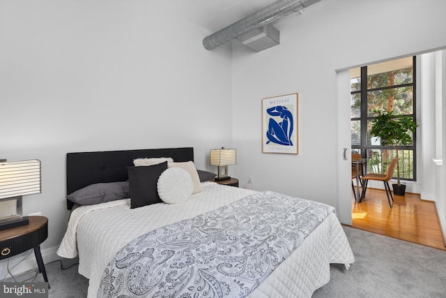 bedroom with multiple windows and wood finished floors