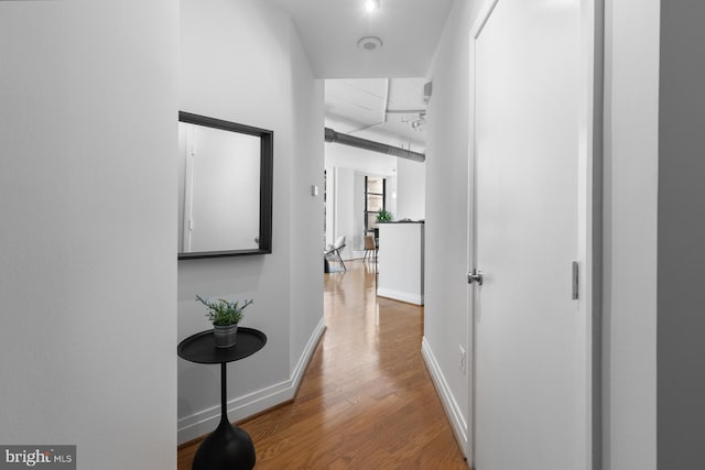 hall featuring baseboards and wood finished floors