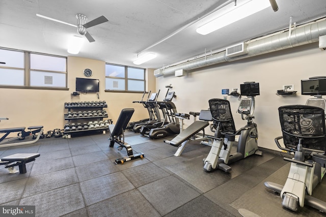 workout area featuring visible vents, ceiling fan, and a wall mounted AC