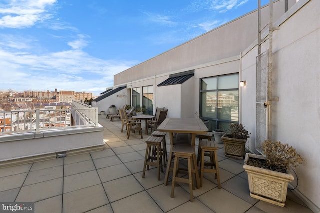 view of patio / terrace featuring a balcony, a view of city, and outdoor dining area