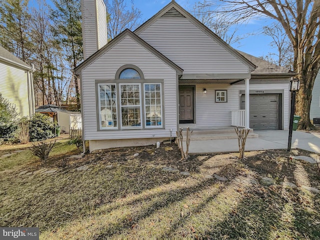 view of front of property with an attached garage, driveway, and a chimney