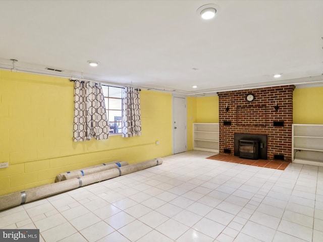 unfurnished living room featuring tile patterned flooring, a wood stove, recessed lighting, and visible vents