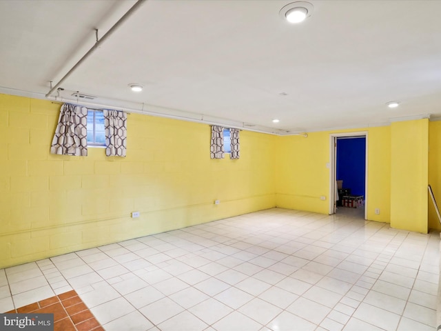 basement featuring light tile patterned floors and concrete block wall