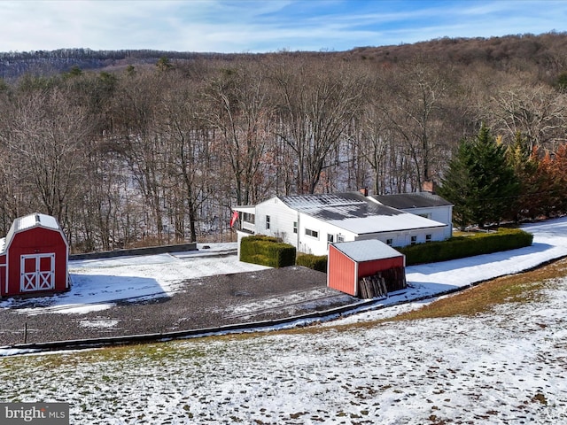 snowy aerial view with a view of trees