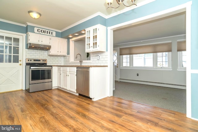 kitchen with under cabinet range hood, stainless steel appliances, baseboard heating, and white cabinets