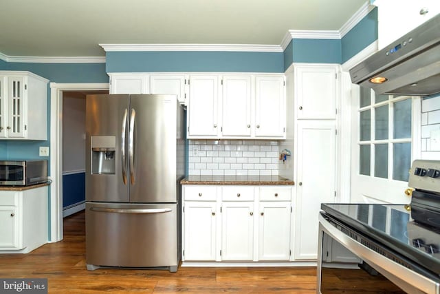 kitchen with backsplash, ventilation hood, ornamental molding, appliances with stainless steel finishes, and white cabinets