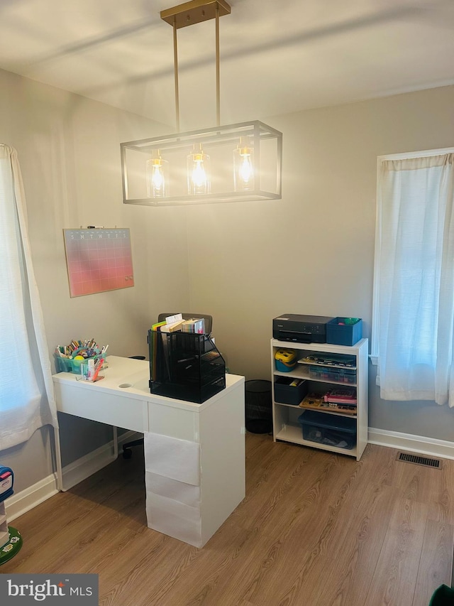 office space with visible vents, baseboards, and wood finished floors