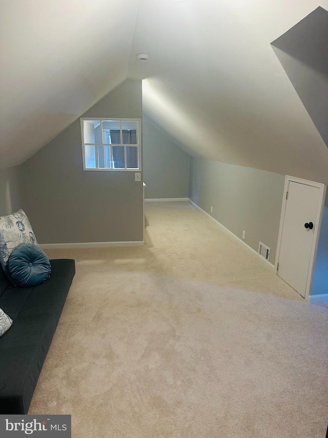 additional living space featuring visible vents, carpet flooring, baseboards, and vaulted ceiling