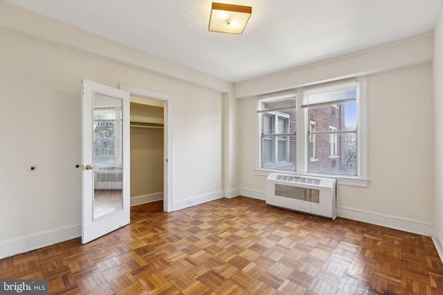 unfurnished bedroom with heating unit, baseboards, and a closet