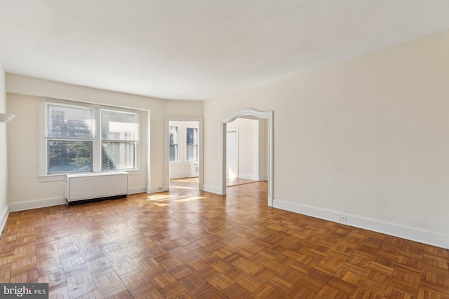 unfurnished room featuring radiator heating unit and baseboards