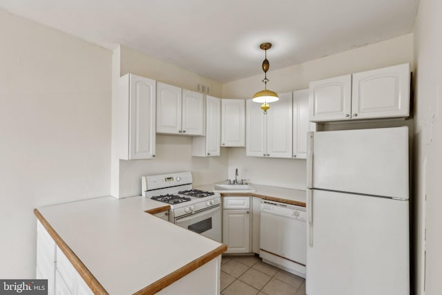 kitchen with a peninsula, hanging light fixtures, white cabinets, white appliances, and a sink