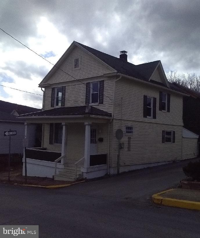 view of front of home featuring a porch and a chimney