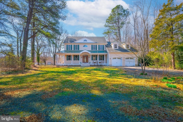 view of front facade with a porch, an attached garage, a front yard, and driveway