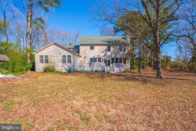 rear view of house featuring a lawn