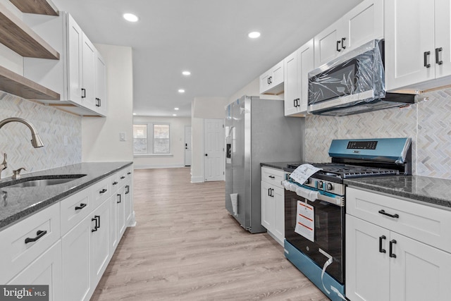 kitchen with open shelves, a sink, white cabinetry, light wood-style floors, and appliances with stainless steel finishes