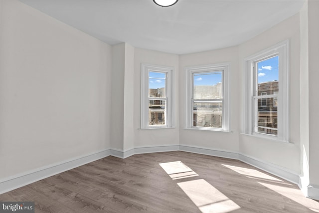 empty room with baseboards and wood finished floors