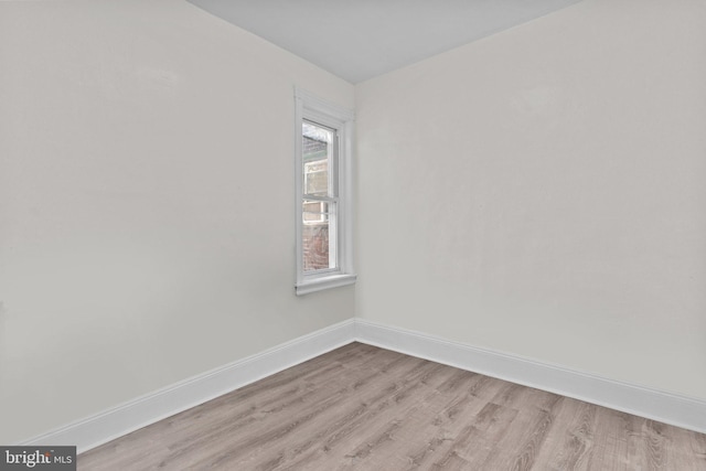 empty room featuring baseboards and light wood-style flooring