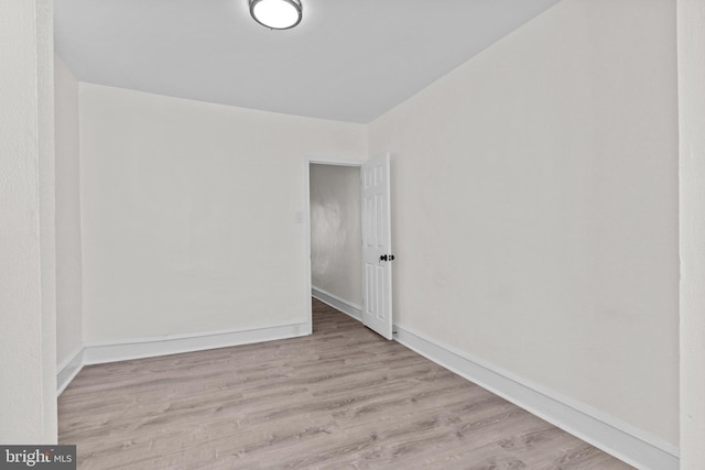 spare room featuring baseboards and wood finished floors