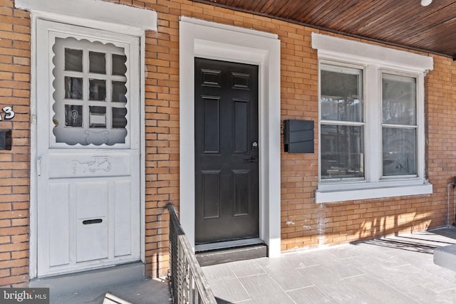 doorway to property featuring brick siding