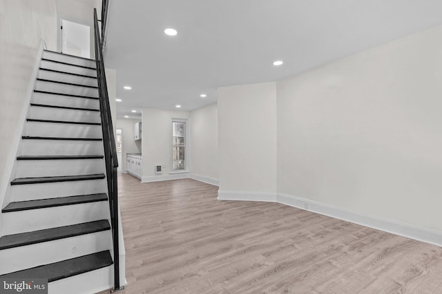 staircase featuring recessed lighting, baseboards, and wood finished floors