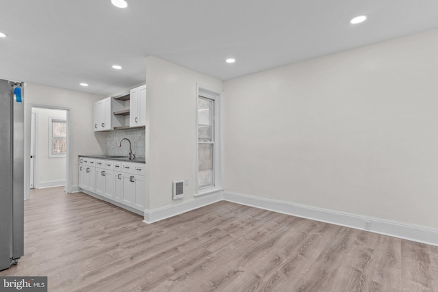 kitchen with dark countertops, visible vents, a sink, light wood-style floors, and open shelves