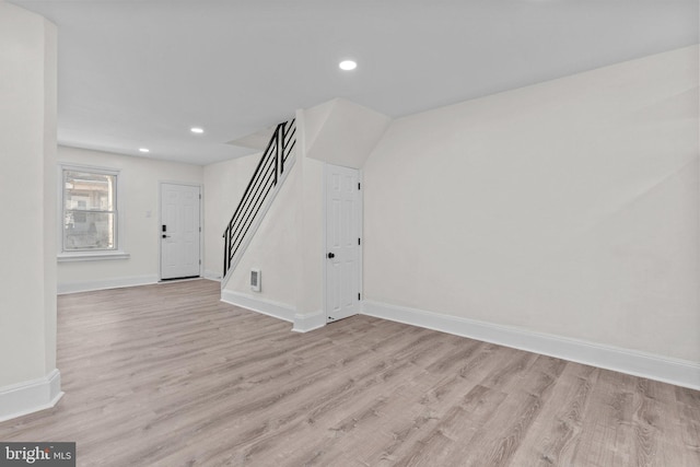 unfurnished living room with light wood finished floors, recessed lighting, stairs, and baseboards