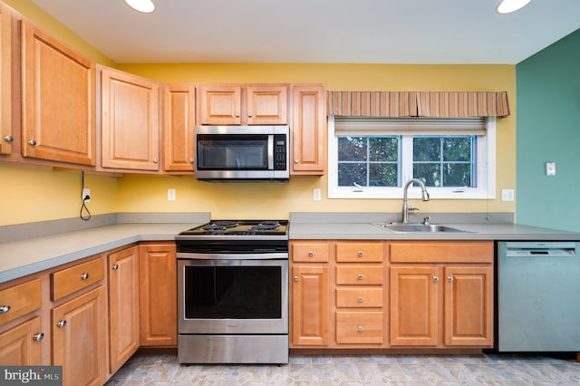 kitchen with stainless steel appliances, light countertops, and a sink