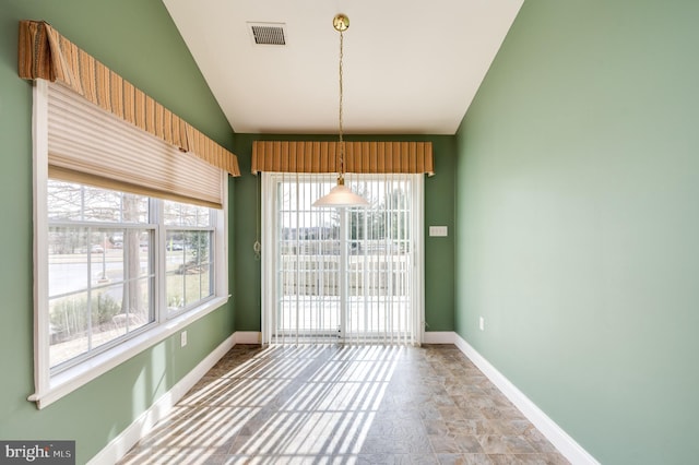 unfurnished dining area featuring visible vents, lofted ceiling, and baseboards