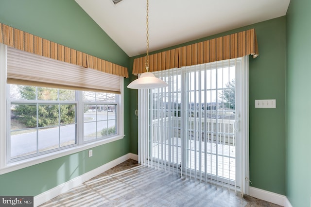 unfurnished dining area with baseboards and vaulted ceiling