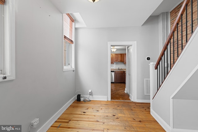 interior space with visible vents, baseboards, light wood-style flooring, and stairway