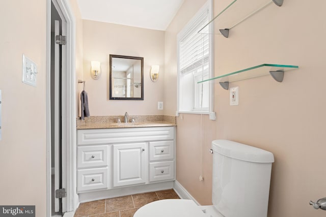 half bath featuring vanity, toilet, and tile patterned flooring