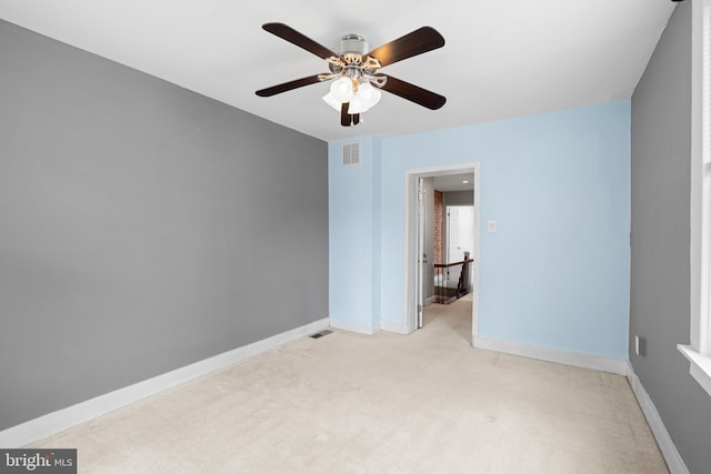 unfurnished bedroom featuring ceiling fan, light colored carpet, visible vents, and baseboards