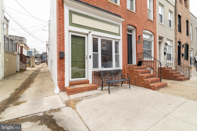 view of exterior entry featuring brick siding