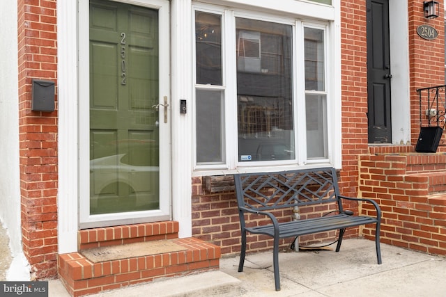 view of exterior entry featuring brick siding