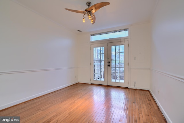 unfurnished room with visible vents, ceiling fan, baseboards, french doors, and wood-type flooring