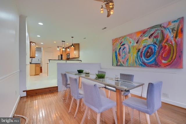 dining area with visible vents, baseboards, and light wood-style flooring