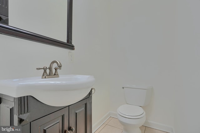 bathroom with tile patterned flooring, toilet, vanity, and baseboards