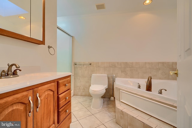 bathroom with toilet, vanity, a bath, tile patterned floors, and tile walls