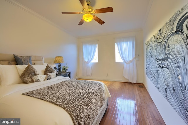 bedroom with baseboards, wood-type flooring, ceiling fan, and crown molding