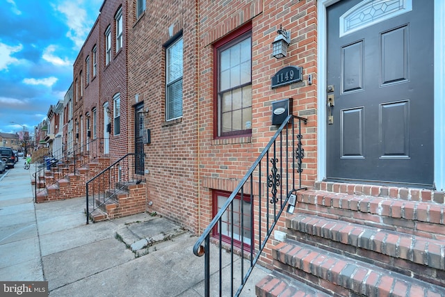 view of exterior entry featuring brick siding