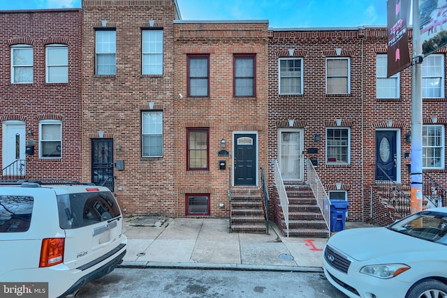 view of property featuring entry steps and brick siding